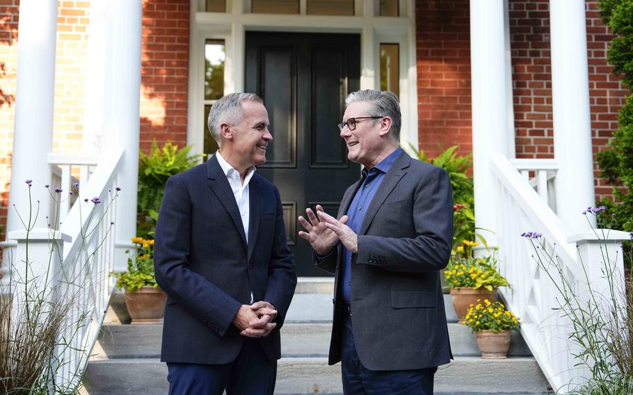 Carney greets Starmer on the steps.