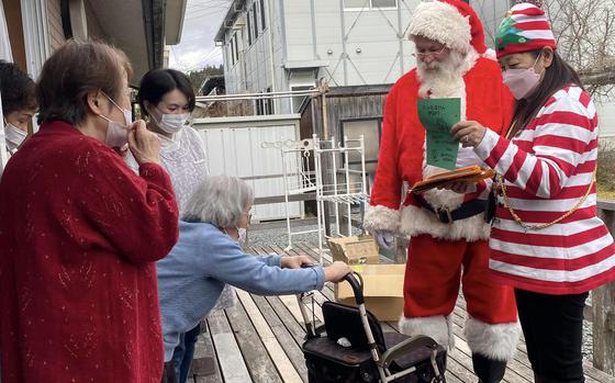 Navy veteran Ervin Lawrence and his wife, Rika, deliver gifts to the elderly in northeastern Japan during a Santa Delivery stop on Dec. 6, 2022. 