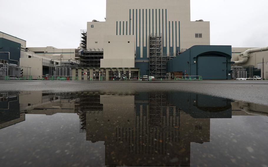The Unit 6 reactor building is reflected in a puddle outside Tokyo Electric Power Co.’s Kashiwazaki Kariwa nuclear power station in Kariwa, Niigata Prefecture, Japan, on Feb. 25, 2015. 
