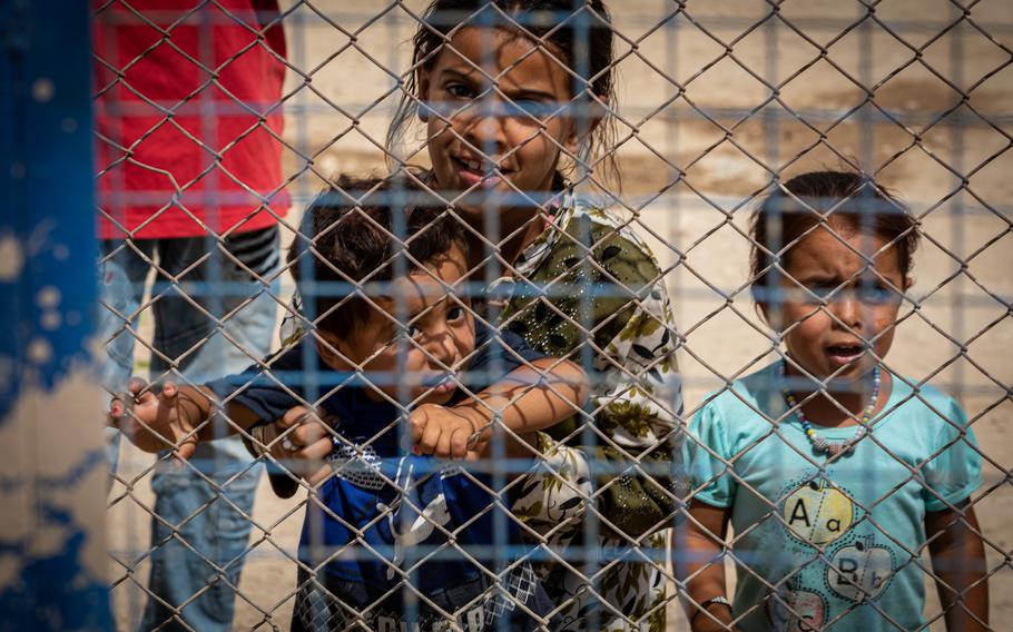 Children look at visiting U.S. troops through the fence at the al-Hol camp for displaced people in Syria, Aug. 21, 2022. There are about 50,000 people at the camp, many of whom are family members of captured Islamic State fighters. Others there fled from ISIS, U.S. officials say.