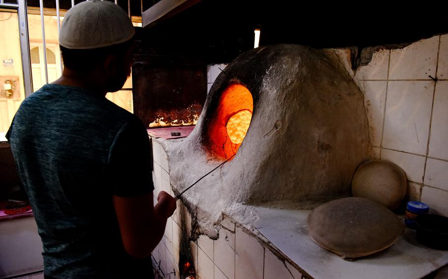 A baker prepares to pull bread from a traditional tannour oven at a bakery near the souk in Muharraq, Bahrain, on April 28, 2024. Bread from local bakeries is a cheap and delicious food option to enjoy while exploring the souk.
