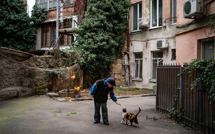 Oleksandr Zayarny, 68, pets one of the cats outside his home in Odesa, Ukraine, on March 6, 2022. 