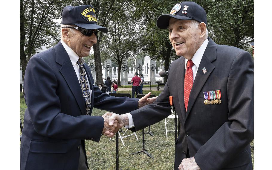 World War II veterans Frank Cohn, left, and Lincoln Harner shake hands at the National World War II Memorial in Washington, D.C., on the 79th anniversary of the start of the D-Day invasion, Tuesday, June 6, 2023.