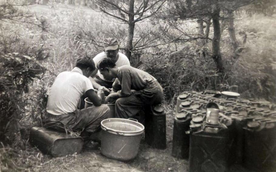 U.S. soldiers sit on jerry cans while working in the field in this undated image from the Korean War.