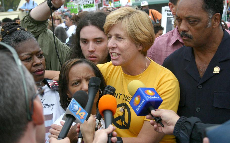 Cindy Sheehan, who organized an anti-war protest outside President Bush’s ranch in Texas after her son was killed in Iraq June 2004, talks to reporters after speaking at the anti-war rally on the Ellipse in Washington, D.C., Sept. 24, 2005. At right is Rev. Jesse Jackson.