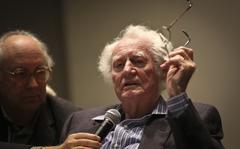 Poet Robert Bly reads from his book "Stealing Sugar from the Castle" at the University of Minnesota on Oct. 16, 2013, in Minneapolis. Holding his microphone is poet Thomas R. Smith. Bly died Sunday, Nov. 21, 2021. He was 94.