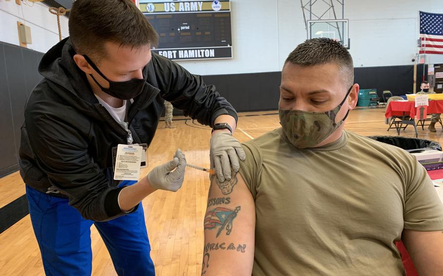 Ian Sheer, a Keller Army Community Hospital at West Point nursing student, administers a coronavirus booster shot to Master Sgt. Jose Rivera of the 1179th Transportation Surface Brigade during a booster shot clinic at the U.S. Army Garrison Fort Hamilton, N.Y., on Feb. 24, 2022. 