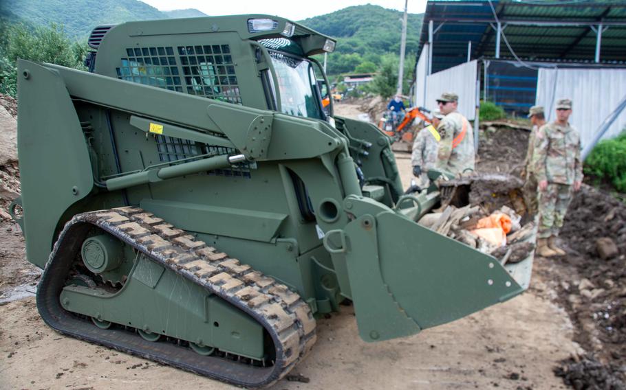 Soldiers of the 11th Engineer Battalion, 2nd Infantry Division use a skid steer to clear debris from recent fatal flooding and landslides in Yecheon county, South Korea, July 27, 2023.