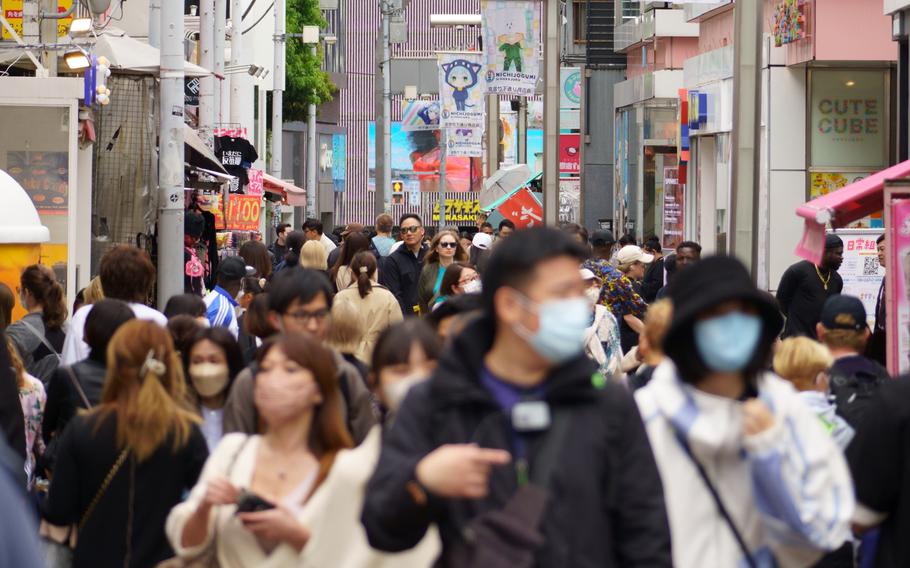 People, both masked and unmasked, stroll Takeshita Street in Tokyo's Harajuku district, Monday, May 8, 2023.
