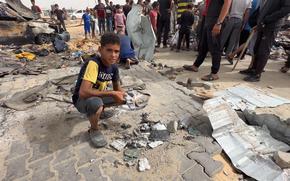 Ahmed, 10, holds munition fragments found near the site of an Israeli airstrike that killed at least 45 people in Rafah in the southern Gaza Strip. Ahmed said he found the fragments in his tent Monday, the day after the strike. MUST CREDIT: Alam Sadeq