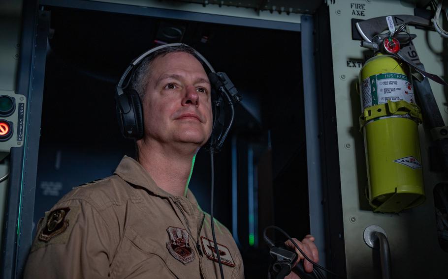 An airman looks out the window of an aircraft.