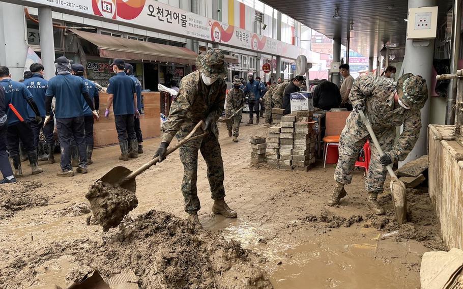 Service members clear mud and debris from Ocheon Market in Pohang, South Korea, Wednesday, Sept. 7, 2022, in the wake of Typhoon Hinnamnor. 