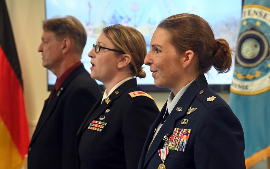 Outgoing commander of Stars and Stripes Europe and Expeditionary, Air Force Lt. Col. Marci Hoffman, incoming commander Army Lt. Col. Katie Fidler and Stars and Stripes publisher Max Lederer, from right, sing at the conclusion of a change of command ceremony July 12, 2023, in Kaiserslautern, Germany. Hoffman is headed for Tokyo, where she will be the Stars and Stripes Pacific commander.