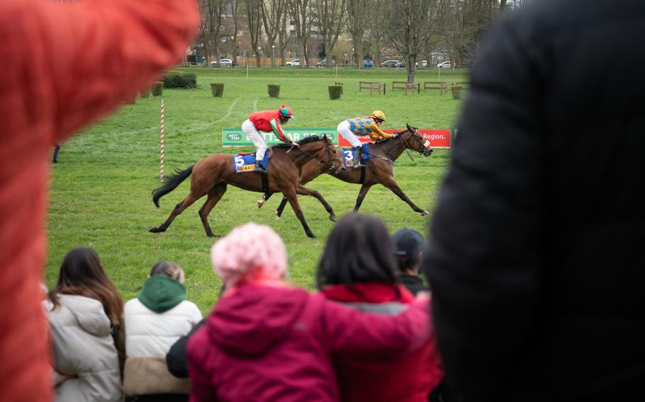 Spectators cheer on horses during the first of two race days held at the historic grass racetrack in Zweibruecken, Germany, Sunday, April 16, 2023. 
