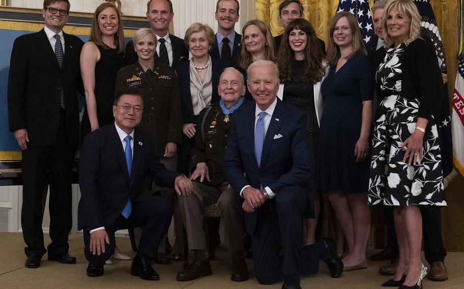 President Joe Biden takes a knee for a group photo with South Korean President Moon Jae-in, kneeling left, after presenting the Medal of Honor to U.S. Army Col. Ralph Puckett, center, in the East Room of the White House, Friday, May 21, 2021.