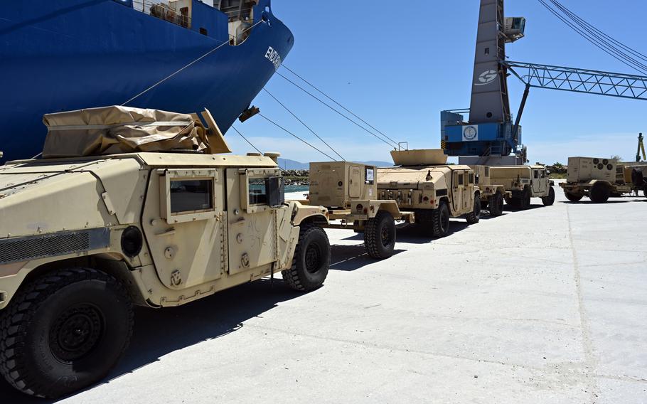 Military vehicles in a line after being unloaded from the cargo ship.