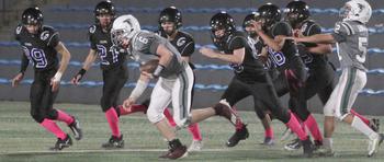 Singapore quarterback Heathe Billingslea tries to run left against an armada of Osan defenders.