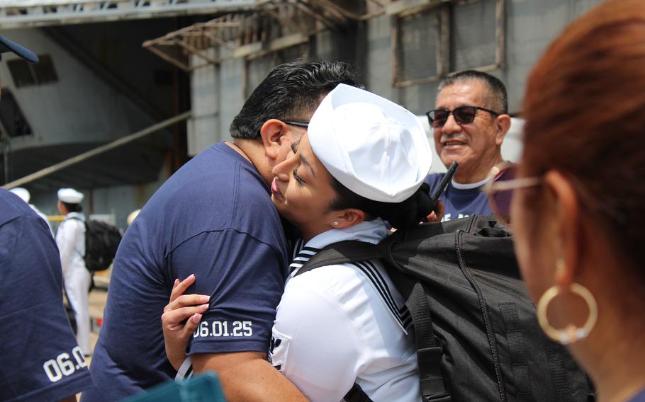 A sailor is greeted by a loved one