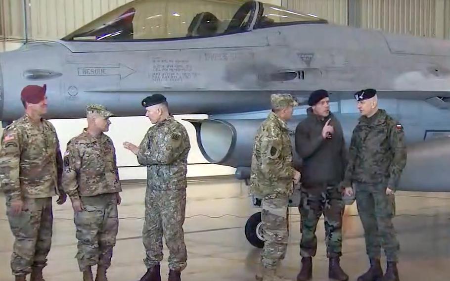 Gen. broni Erik Kurilla, dowódca XVIII Korpusu Powietrznodesantowego, po lewej, gen. Christopher G. Cavoli, dowódca Armii USA Europa-Afryka, drugi od lewej, i gen. Sił Powietrznych Tod Wolters, Naczelny Dowódca Sił Sojuszniczych NATO, rozmawiają ze swoimi odpowiedniki przed polskim odrzutowcem F-16 w bazie lotniczej Łask, Polska, 1 marca 2022 r. 