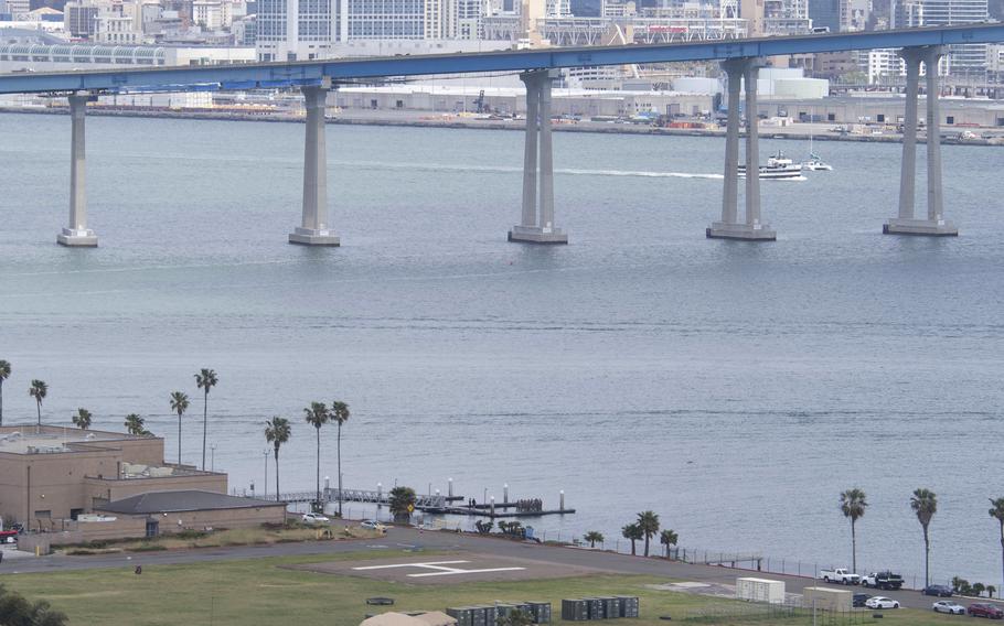 The San Diego skyline in the upper third of the image while a body of water takes most of the center and some tents take up the bottom third.