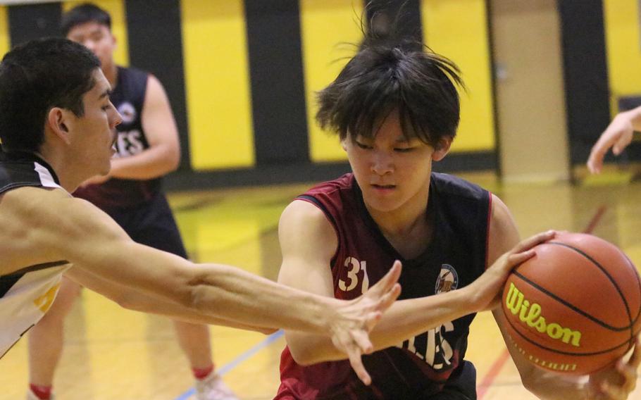 American School Bangkok's Tandem Thampornpipat plays keepaway against Kadena's Noah Ray during Monday's Far East Boys Division I pool-play game, won by the Panthers 37-28.