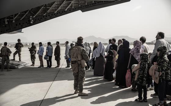 Evacuees wait to board a Boeing C-17 Globemaster III at Hamid Karzai International Airport, Kabul, Afghanistan, Aug. 30, 2021. Afghans evacuated by the U.S. are kept under constant surveillance in the United Arab Emirates, Human Rights Watch said in a report March 15, 2023.  