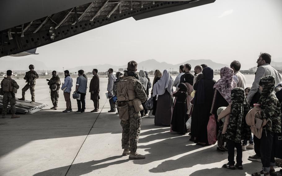 Evacuees wait to board a Boeing C-17 Globemaster III at Hamid Karzai International Airport in Kabul, Afghanistan, Aug. 30, 2021. Afghans evacuated by the U.S. are kept under constant surveillance in the United Arab Emirates, Human Rights Watch said in a report March 15, 2023.  