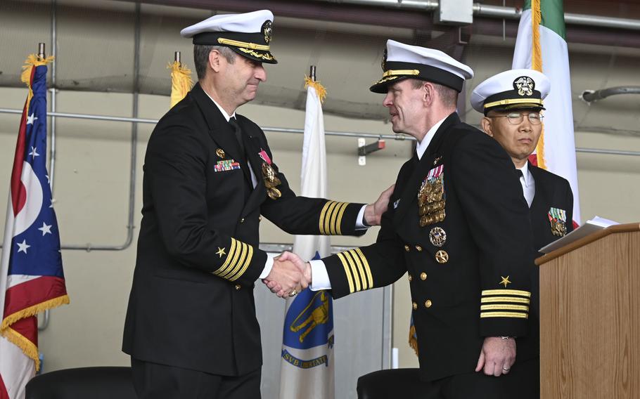 Capt. Kevin Pickard, left, congratulates incoming base commander Capt. Aaron Shoemaker at NAS Sigonella, Italy, April 29, 2022. Pickard had served as commanding officer at Sigonella since April 2019. 