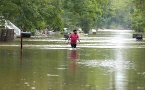 A man walks through floodwaters in Woodloch, Texas, on May 4, 2024.
