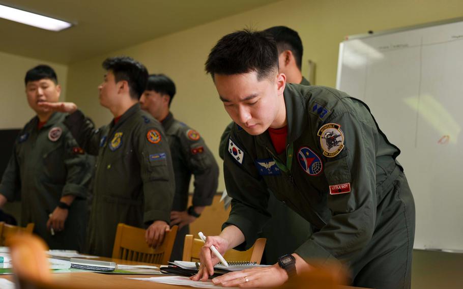 South Korean airmen look over papers.