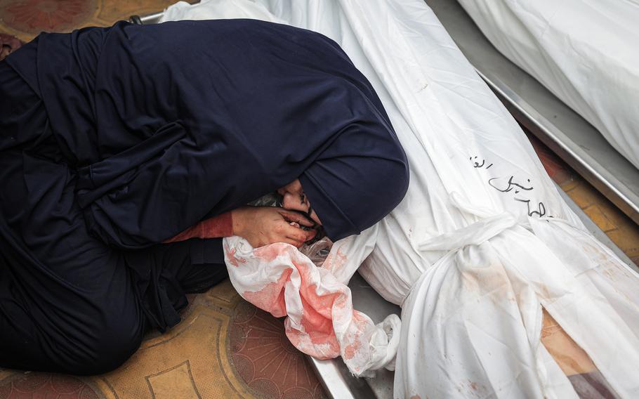 A relative mourns Palestinians killed in an Israeli airstrike ahead of their burials in Khan Younis, Gaza, on Tuesday, Dec. 5, 2023.