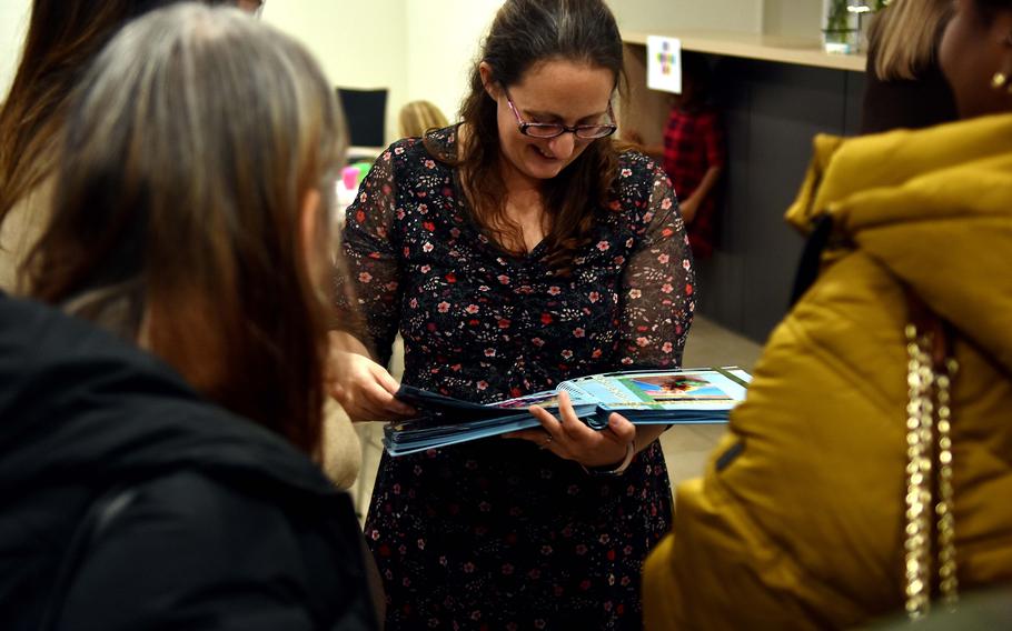 Jordan Anders holds an album of photos while surrounded by attendees at her son’s memorial service.