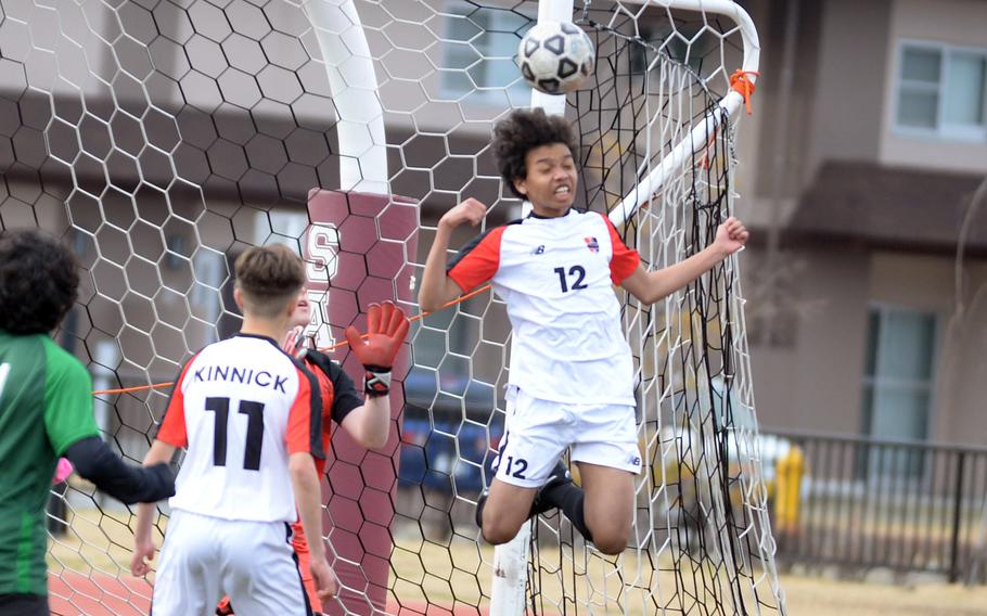 Nile C. Kinnick's Cameron Giddens heads the ball in front of the net during a corner kick by Kubasaki during Saturday's Perry Cup Gold Group match. The Red Devils won 3-2.