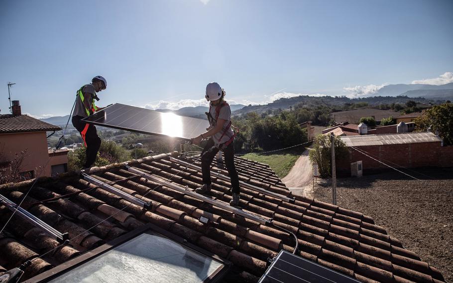 Installing solar panels onto the roof of a home in Spain in September 2022. 