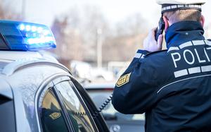 A German police officer speaks into his patrol car’s radio.