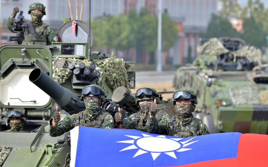 Members of Taiwan’s 564th Armored Brigade pose with their flag after demonstrating their ability to repel an airborne attack near Kaohsiung, Taiwan, Jan. 11, 2023.