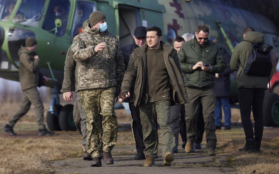 Ukrainian President Volodymyr Zelenskyy, center, arrives to attend a military drill outside the city of Rivne, northern Ukraine, Wednesday, Feb. 16, 2022.