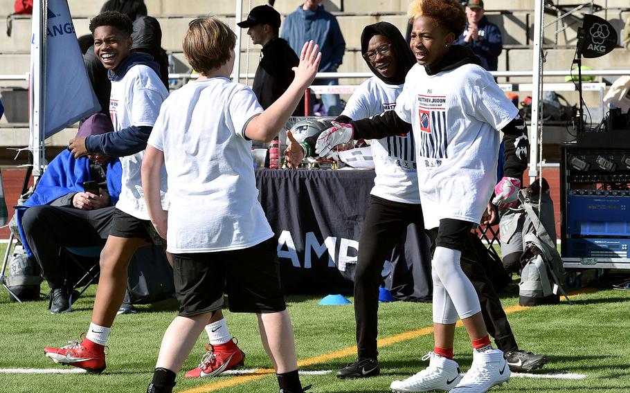Michaden Sanders, 12, a Ramstein student, celebrates with other participants after scoring on New England Patriots outside linebacker Matthew Judon on March 23, 2024, at Kaiserslautern High School in Kaiserslautern, Germany. The drill was a part of the Matthew Judon Football ProCamp held at the school over Saturday and Sunday.
