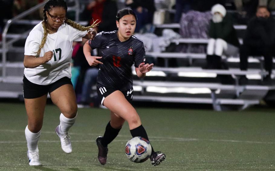 Nile C. Kinnick's Ella Louise Cala dribbles in front of Robert D. Edgren's Jordan Watson during Friday's DODEA-Japan girls soccer match. The Red Devils won 11-0.