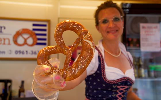 A woman shows off a pretzel.