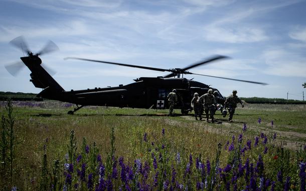 Soldiers carry Brig. Gen. Clinton Murray, commanding general of Medical Readiness Command Europe, from a UH-60 Black Hawk medevac helicopter to a field hospital near Bordusani, Romania, June 6, 2023, during Exercise Saber Guardian. 