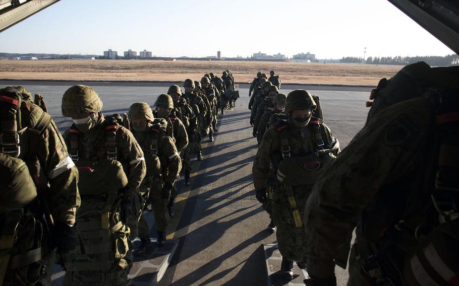 Troops from the Japan Ground Self-Defense Force load onto a C-130J Super Hercules at Yokota Air Base, Japan, Tuesday, Jan. 25, 2022.