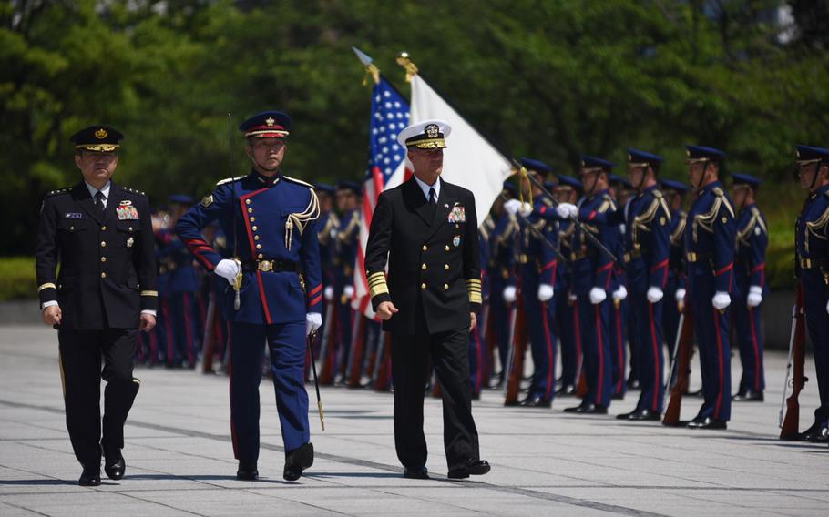 Adm. John Aquilino reviews troops outside Japan's Ministry of Defense in Tokyo during his first overseas trip as leader of U.S. Indo-Pacific Command, Tuesday, June 1, 2021.