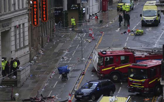 The street scene with emergency vehicles and abandoned cars.