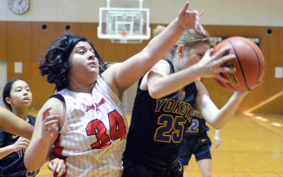 Yokota's Ami Sylla snags a rebound in front of Nile C. Kinnick's Alyssa Lopez during Friday's ASIJ Kanto Classic quarterfinal. The Red Devils won 40-15 to stay unbeaten at 16-0. They face Okkodo of Guam in Saturday's semifinal.