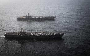 Two aircraft carriers at sea.