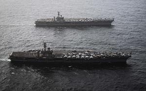 Two aircraft carriers at sea.
