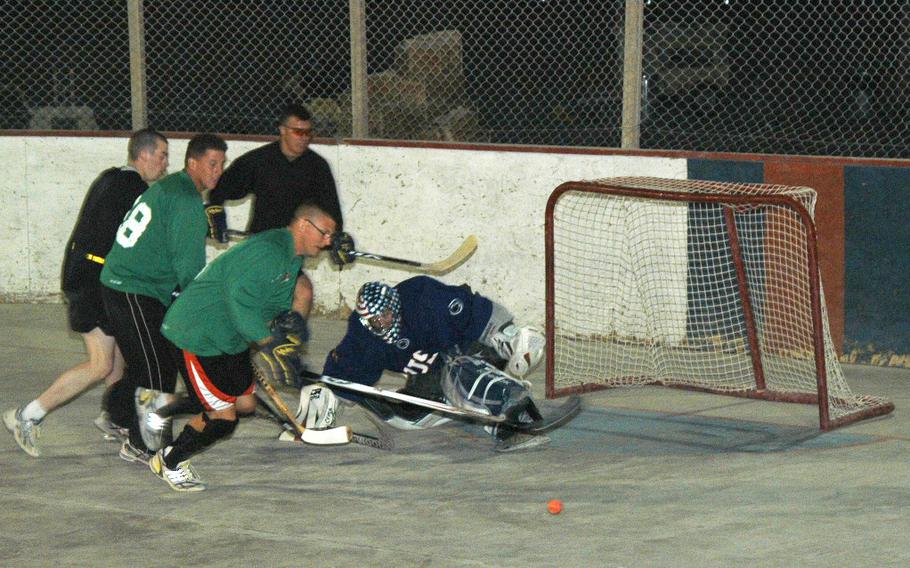 Capt. Ken Schoonover, the goalie and outgoing captain of the U.S. team in the ball hockey league at Kandahar Air Field, makes a kick save during a recent scrimmage of American players in southern Afghanistan.