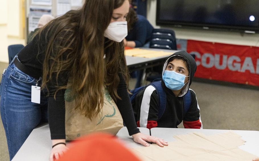 Abid, right, listens to instructions from Brielle Cosgrove, a World Relief Seattle staffer, during a new after-school program for refugee children, run by the resettlement agency World Relief, at Mill Creek Middle School in Kent, Washington, on Tuesday, Feb. 15, 2022.