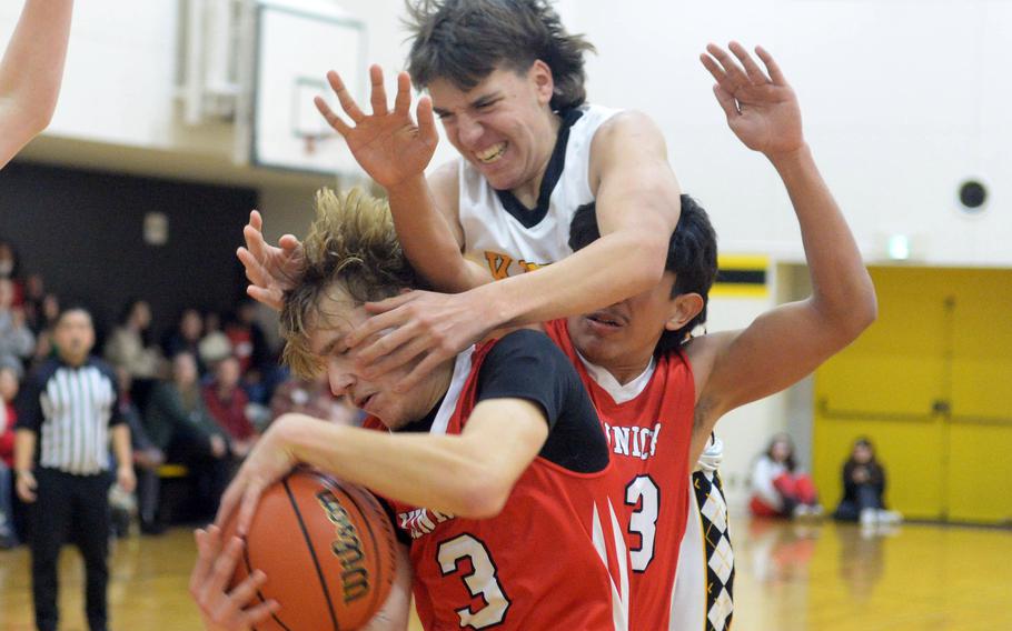Kadena’s Mark Francis climbs over Kinnick’s Javier Arroyo to try to get to the ball in the hands of Kinnick’s Derek Ulrich.